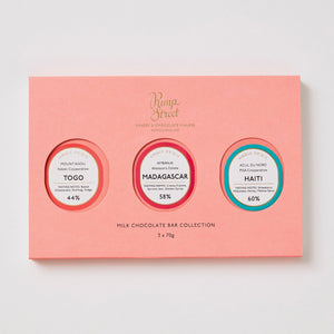Pink chocolate bar collection packaging with three circular labels on a light gray background