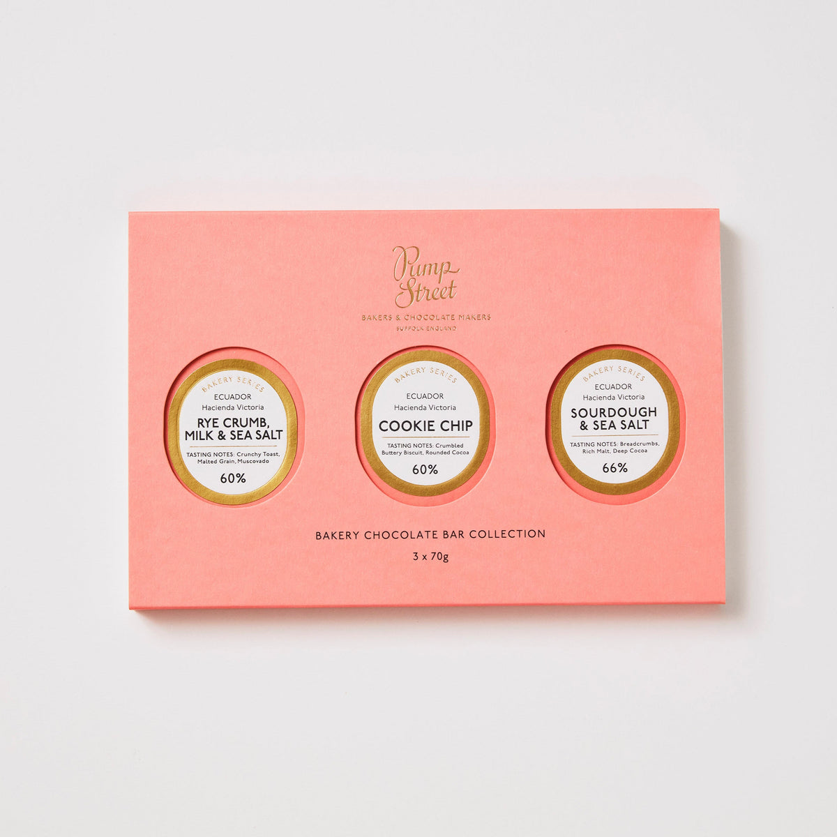 Pink chocolate bar collection packaging with three round labels on a white background