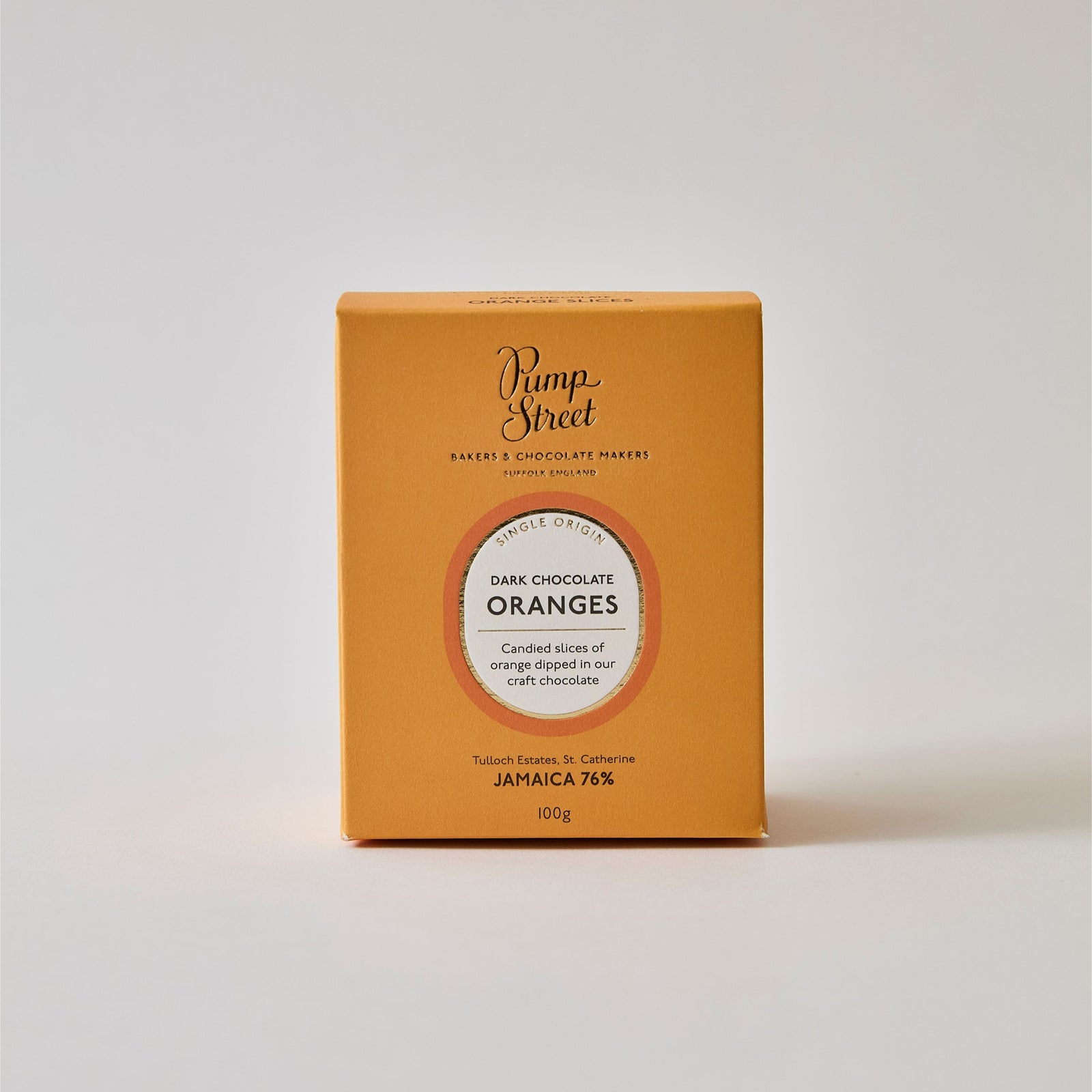 Box of oranges, with one chocolate dipped orange leaning up against it