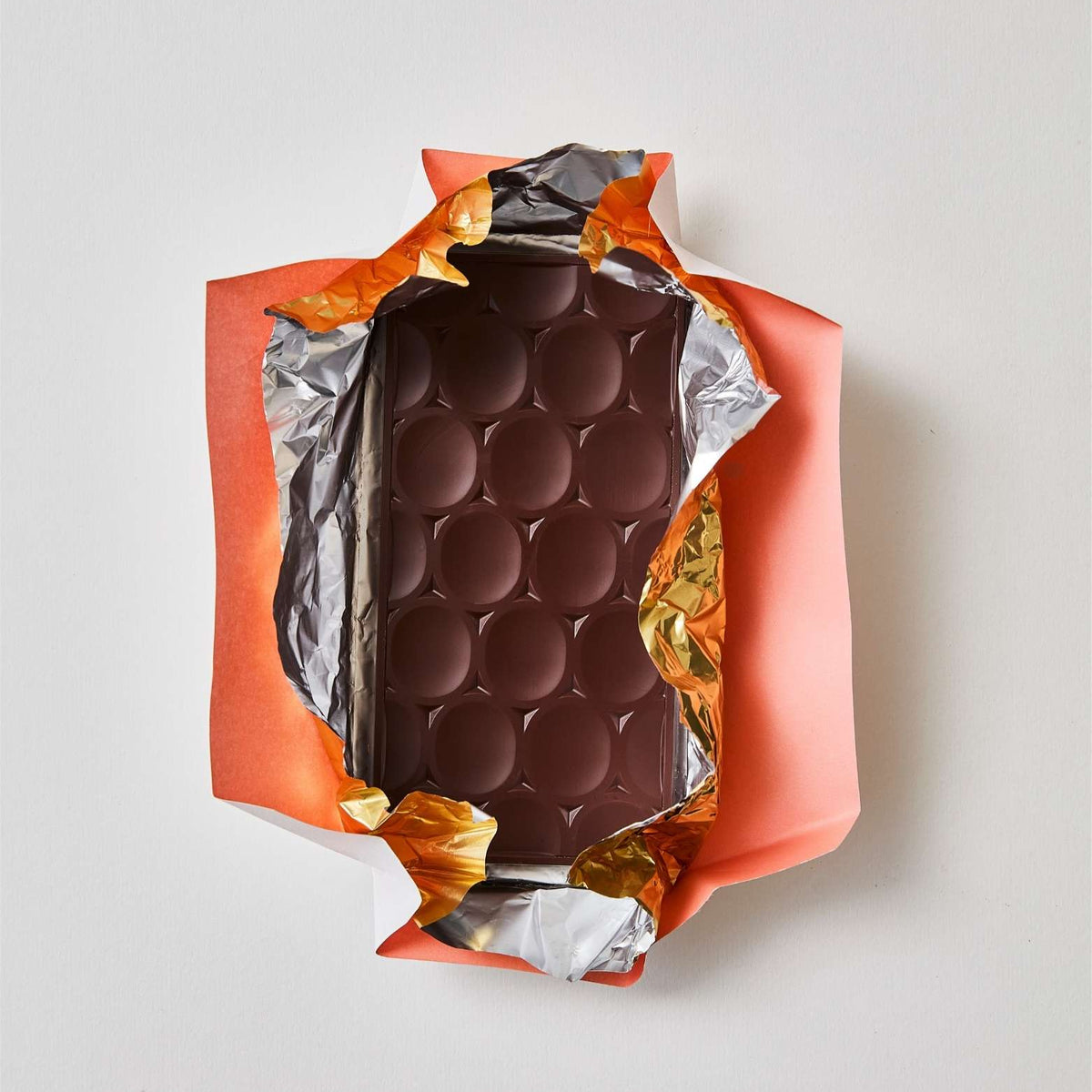 Opened chocolate bar, wrapped in foil and then pink paper